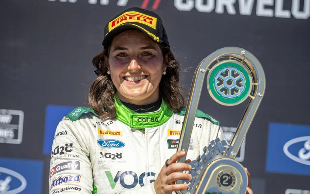 Tatiana Calderón smiling in a racing suit and holding a trophy at Curvelo.